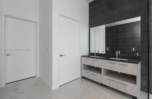 a bathroom with a double vanity sink and mirror