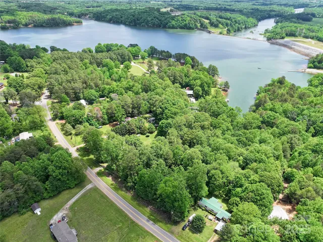 an aerial view of a house with yard and lake view