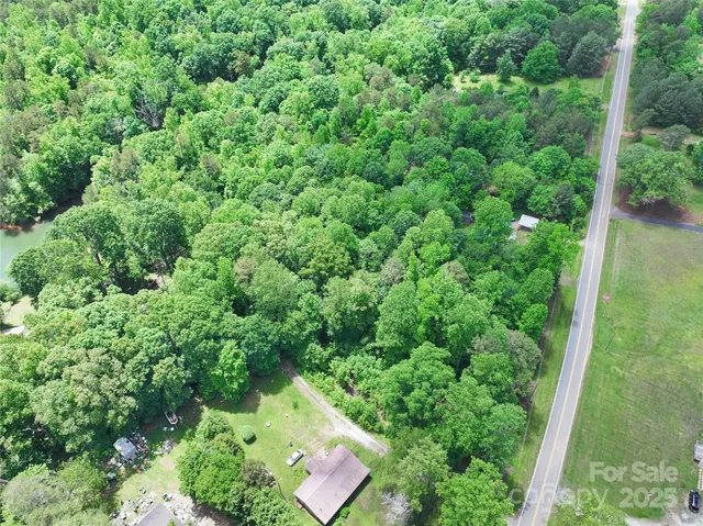 an aerial view of a house with a yard and lake view