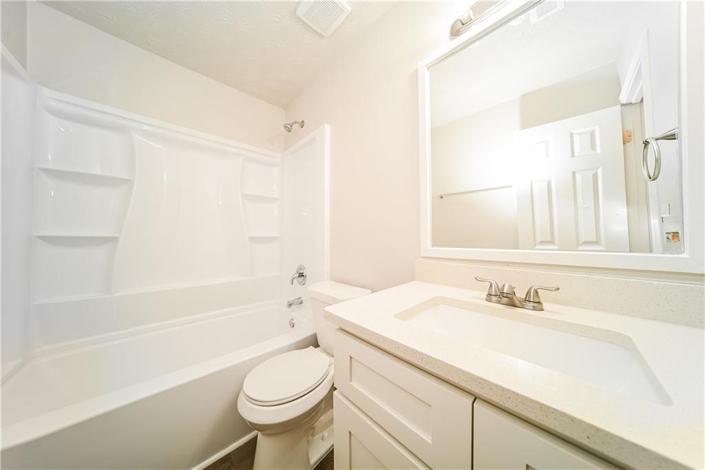 11171 Knotty Pine Place Hampton, GA 30228 - Photo 19 of 26 a bathroom with a sink a toilet and a bathtub