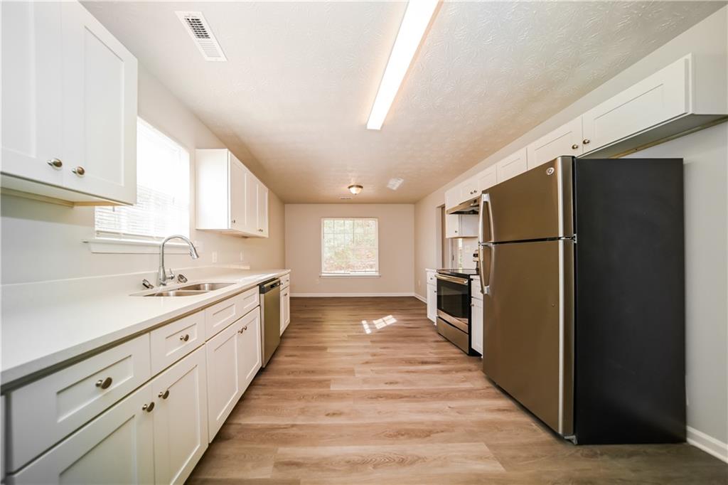 11171 Knotty Pine Place Hampton, GA 30228 - Photo 5 of 26 a large kitchen with a refrigerator and a sink