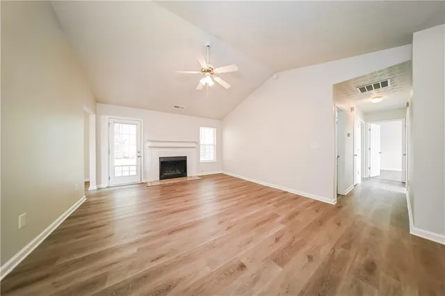 a view of empty room with wooden floor and fireplace