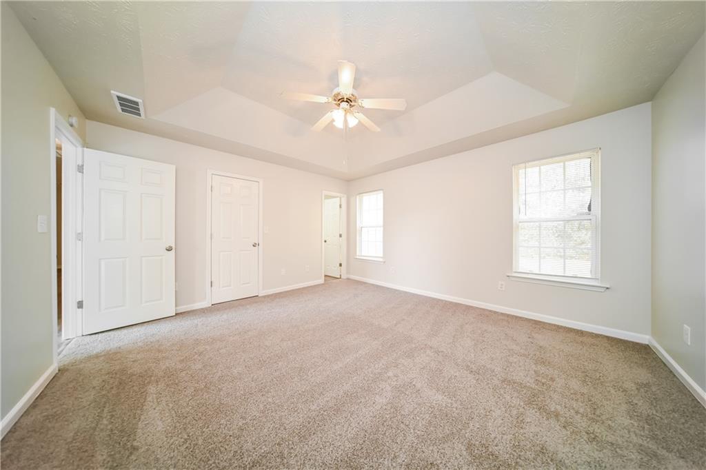 11171 Knotty Pine Place Hampton, GA 30228 - Photo 10 of 26 an empty room with chandelier fan and windows