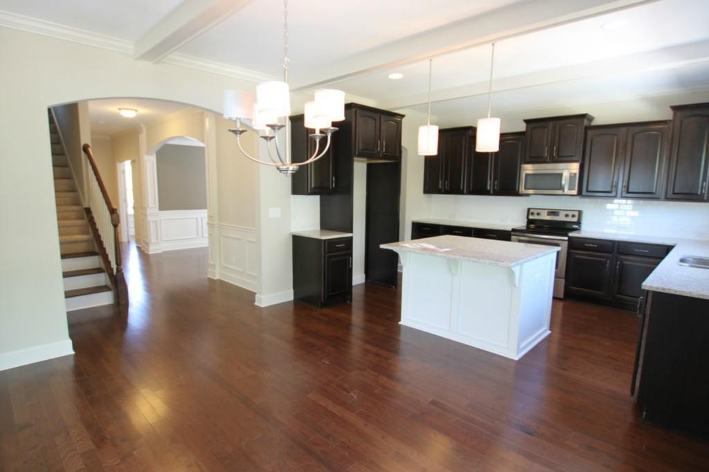 2191 Bluebell Way, Unit 11 Tega Cay, SC 29708 - Photo 3 of 14 a kitchen with stainless steel appliances kitchen island granite countertop a refrigerator a stove and a wooden floors