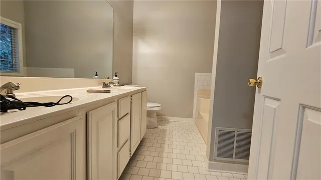 a bathroom with a sink a toilet and a mirror