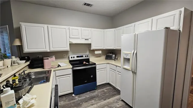 a kitchen with stainless steel appliances granite countertop a refrigerator stove and sink
