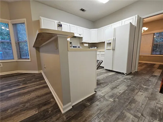 a view of a kitchen with refrigerator and windows