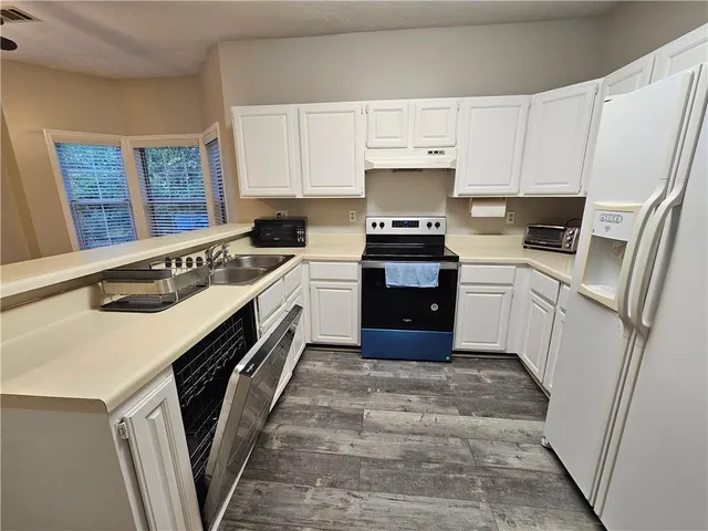 a kitchen with stainless steel appliances a stove a sink and a refrigerator