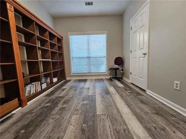 a view of empty room with wooden floor and windows