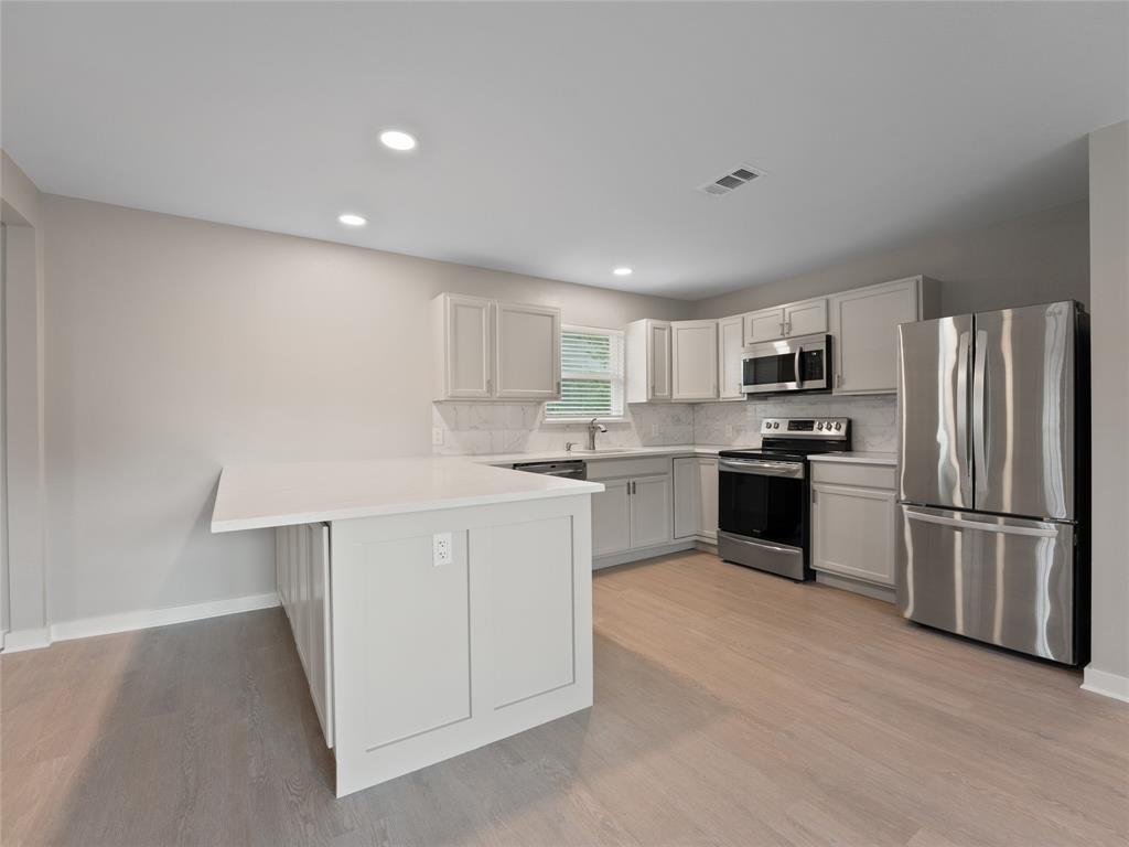 421 South Interurban Street Anna, TX 75409 - Photo 1 of 27 a kitchen with a refrigerator a sink and white cabinets