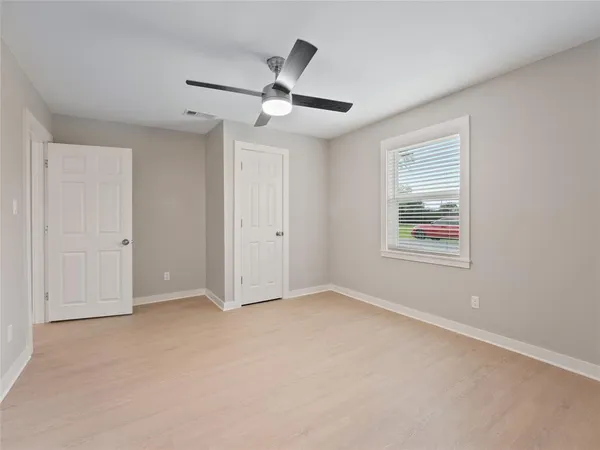 an empty room with closet and ceiling fan