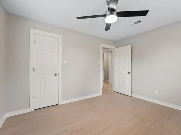 an empty room with a window and a ceiling fan
