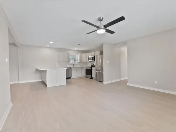 a view of an empty room with a kitchen
