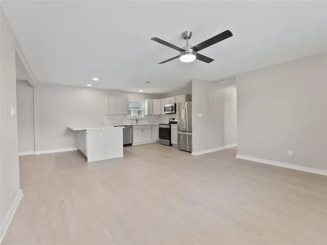 a view of an empty room with a kitchen