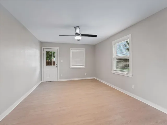 a view of a livingroom with a ceiling fan & windows