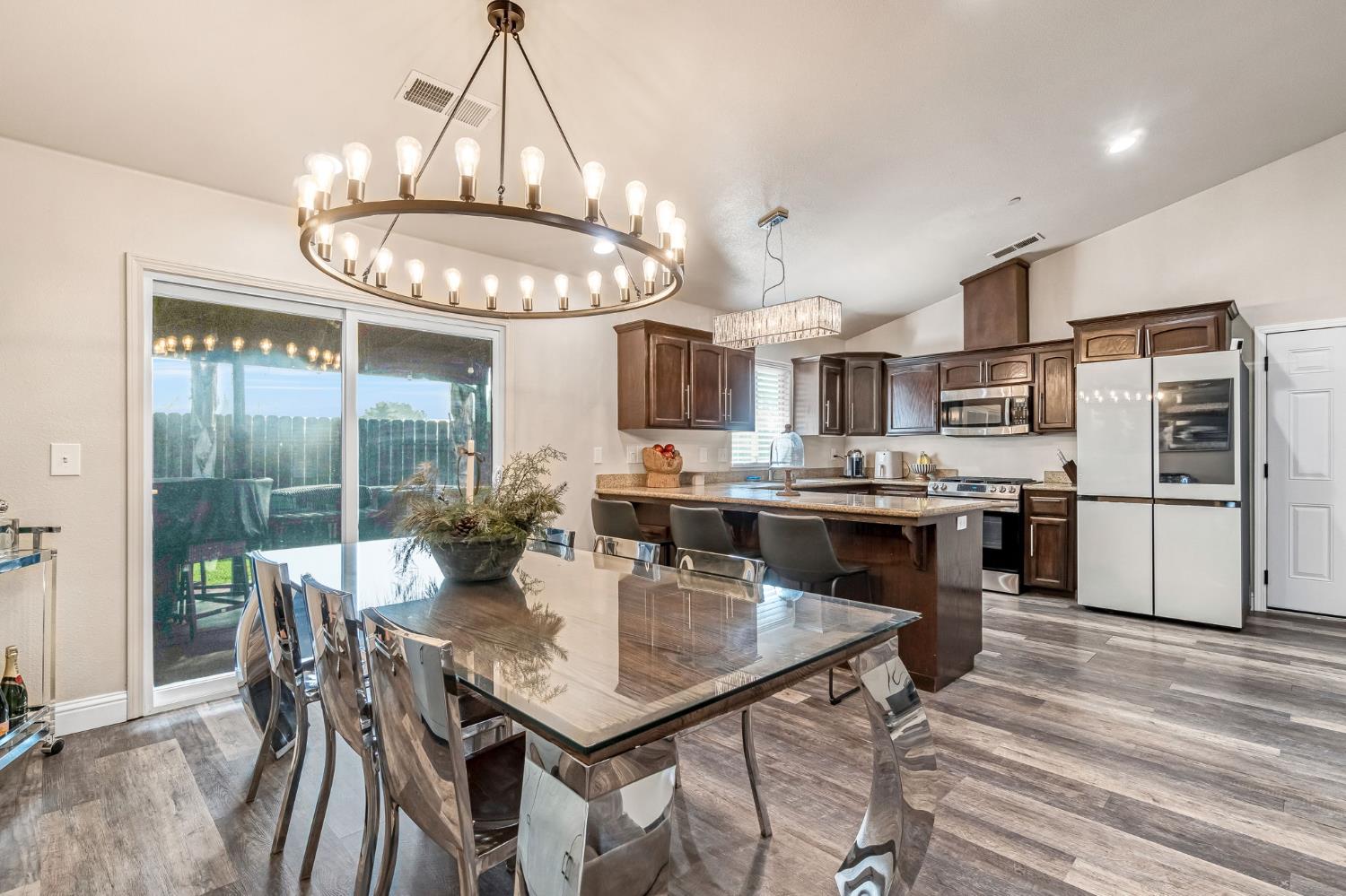 25802 El Monte Way Madera, CA 93638 - Photo 11 of 39 dining space featuring vaulted ceiling, dark wood-style floors, and suspended lighting