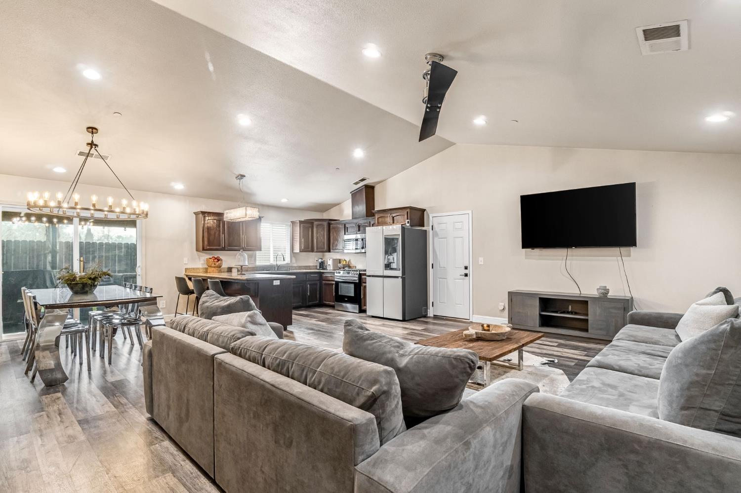 25802 El Monte Way Madera, CA 93638 - Photo 5 of 39 living room featuring light wood-type flooring, lofted ceiling, and suspended lighting