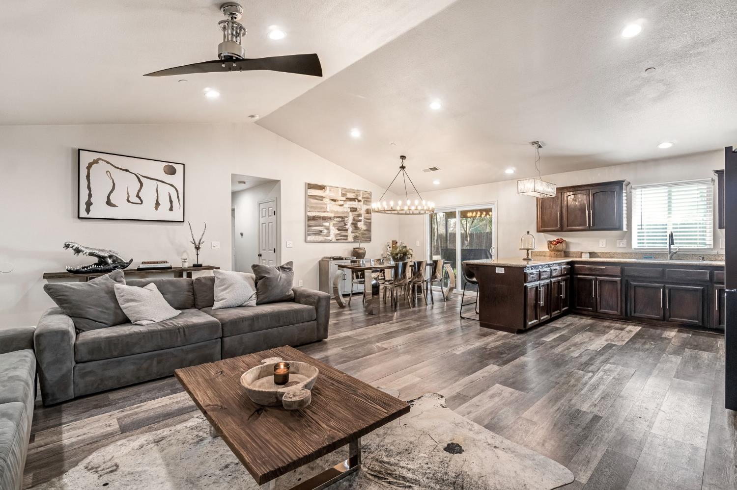 25802 El Monte Way Madera, CA 93638 - Photo 8 of 39 living room with dark wood-style floors, ceiling fan, and a chandelier