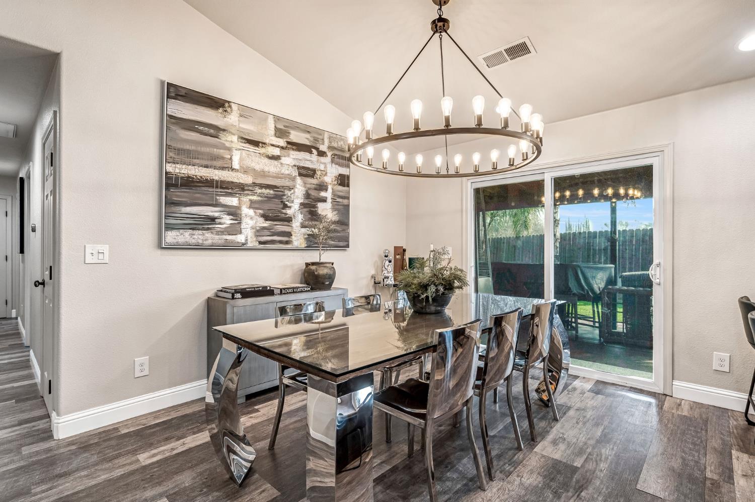 25802 El Monte Way Madera, CA 93638 - Photo 10 of 39 dining room featuring dark wood-type flooring, lofted ceiling, and a chandelier