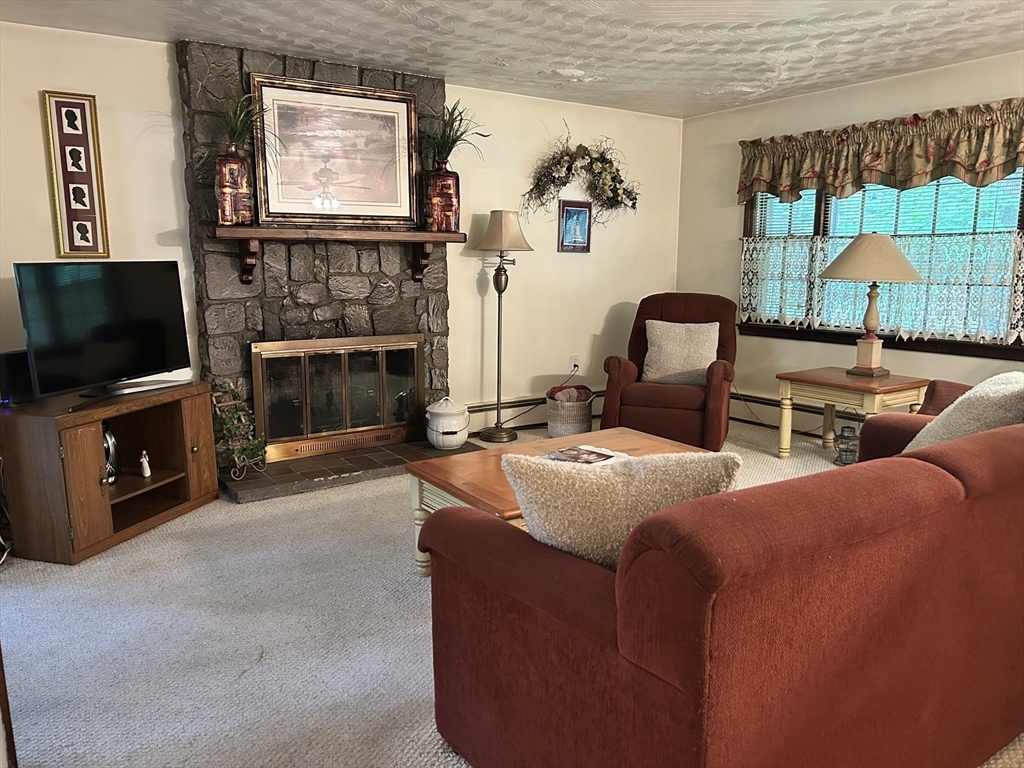 58 Summer Hill Road Maynard, MA 01754 - Photo 4 of 15 a living room with furniture a flat screen tv and a fireplace
