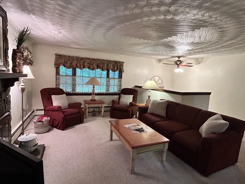 58 Summer Hill Road Maynard, MA 01754 - Photo 5 of 15 a living room with furniture a floor to ceiling window and a flat screen tv