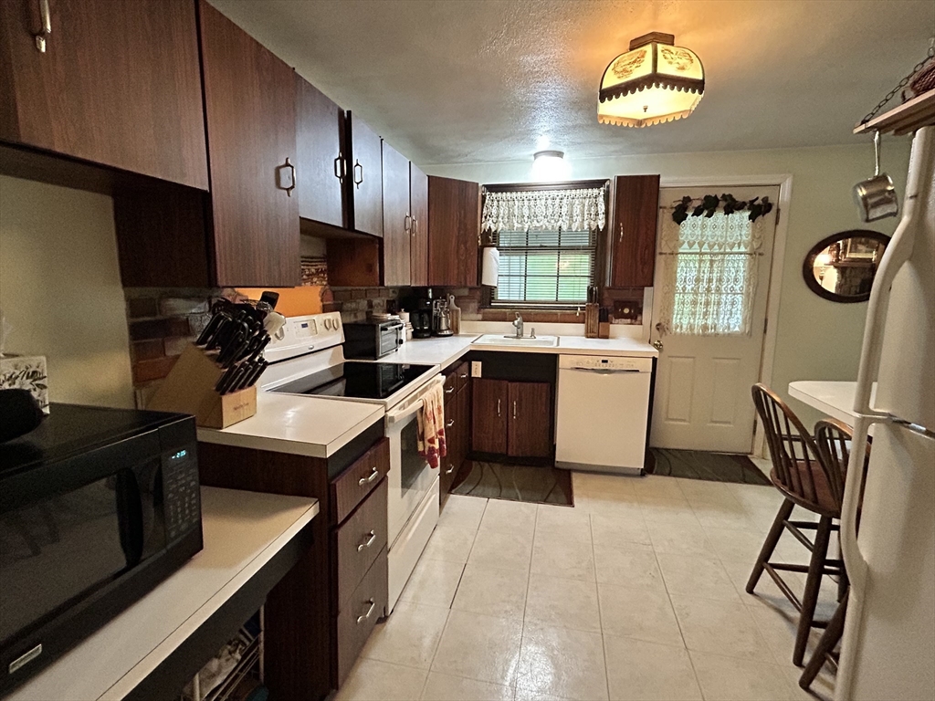 58 Summer Hill Road Maynard, MA 01754 - Photo 7 of 15 a kitchen with a stove a sink and a refrigerator
