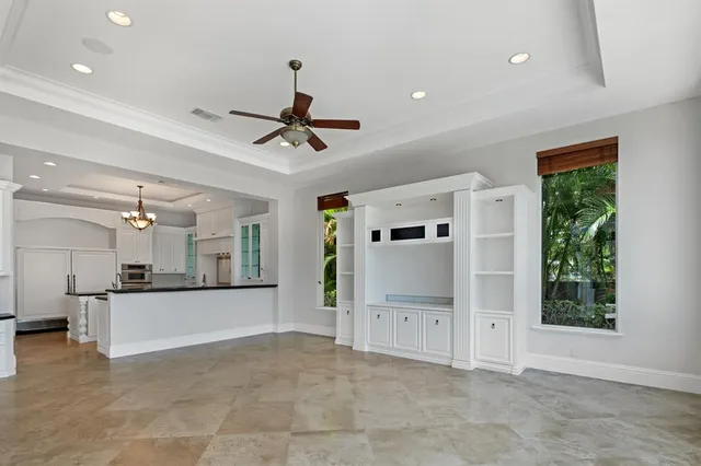 a large kitchen with granite countertop a sink and white cabinets