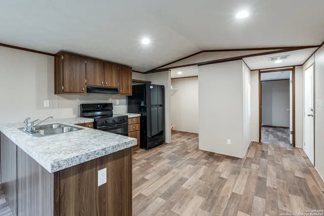 a kitchen with stainless steel appliances granite countertop a refrigerator stove and oven