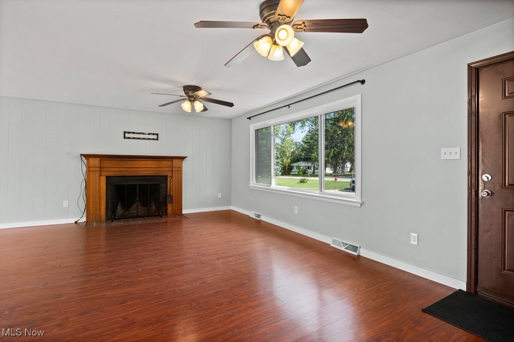5956 Ryan Road Medina, OH 44256 - Photo 3 of 27 Unfurnished living room featuring dark wood-type flooring, a fireplace, and ceiling fan