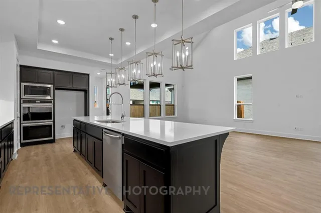 a kitchen with kitchen island a sink counter top space and stainless steel appliances