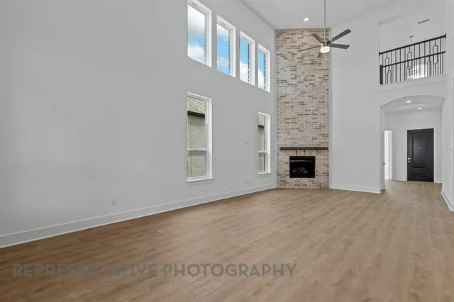 an empty room with windows and fireplace