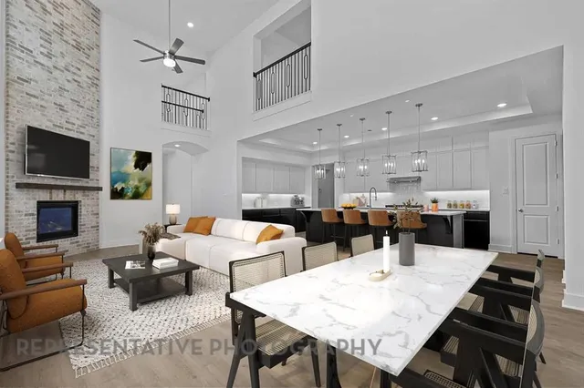 a large living room with stainless steel appliances kitchen island a table and chairs