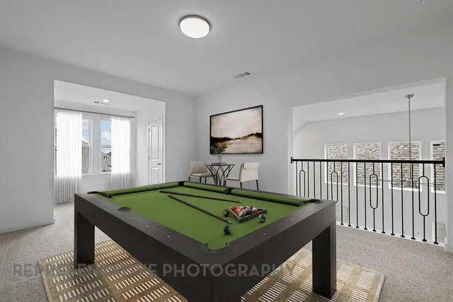 a room with pool table and a rug