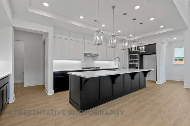 a large kitchen with kitchen island a sink stainless steel appliances and cabinets