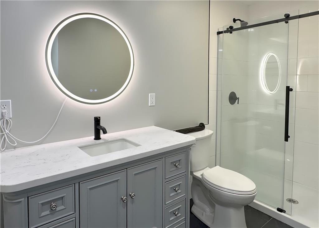 422 Walnut Street, Unit 2 Sewickley, PA 15143 - Photo 11 of 12 a bathroom with a granite countertop toilet sink and mirror