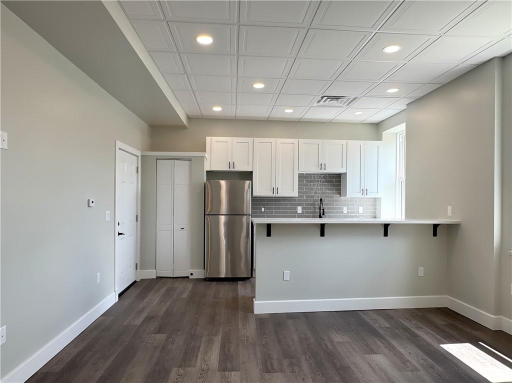 422 Walnut Street, Unit 2 Sewickley, PA 15143 - Photo 5 of 12 a kitchen with stainless steel appliances granite countertop a refrigerator a sink a stove a microwave and white cabinets