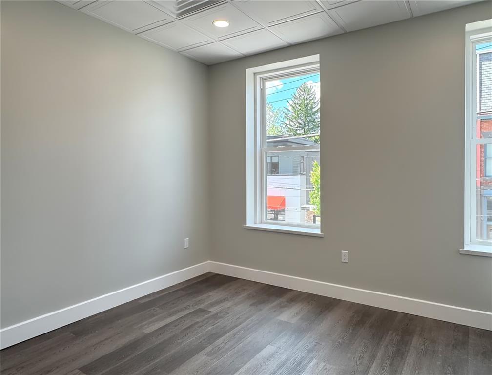 422 Walnut Street, Unit 2 Sewickley, PA 15143 - Photo 6 of 12 an empty room with wooden floor and windows