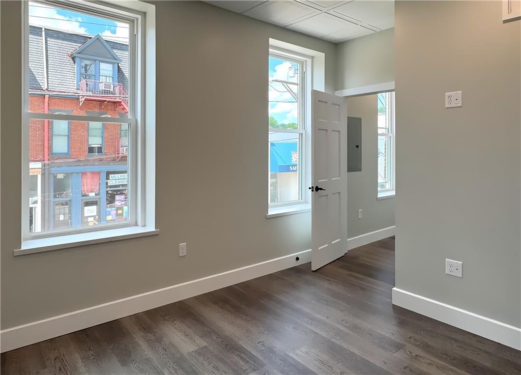 422 Walnut Street, Unit 2 Sewickley, PA 15143 - Photo 8 of 12 an empty room with wooden floor and windows