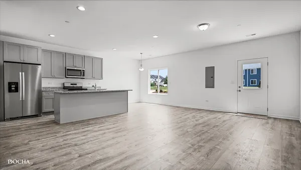 a view of kitchen with granite countertop cabinets and refrigerator