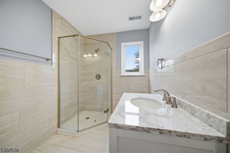 2535 Standish Avenue Union, NJ 07083 - Photo 16 of 45 a bathroom with a granite countertop sink a shower and mirror