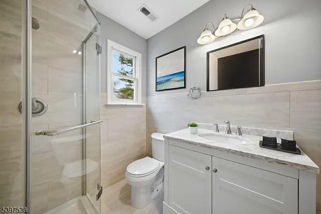 a bathroom with a toilet sink a mirror and vanity