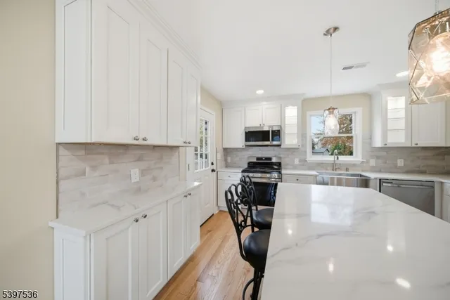 a kitchen with stainless steel appliances a sink a stove top oven a counter space and cabinets