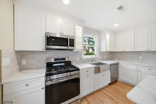 a kitchen with stainless steel appliances granite countertop a stove a sink and a microwave