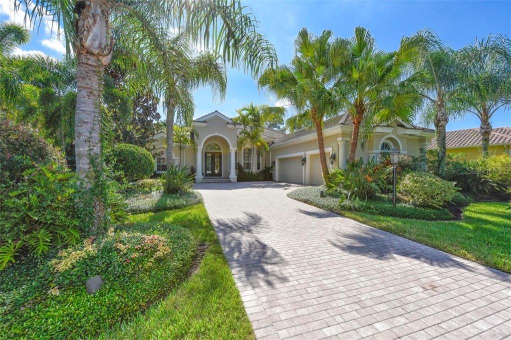 7509 Greystone Street Lakewood Ranch, FL 34202 - Photo 1 of 1 a front view of a house with a garden and trees