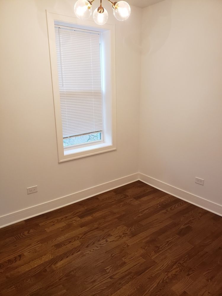 2347 West Taylor Street, Unit 3R Chicago, IL 60612 - Photo 4 of 9 an empty room with wooden floor and windows