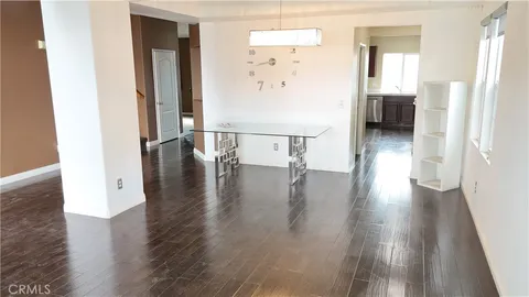 an entryway with wooden floor and a view of bathroom