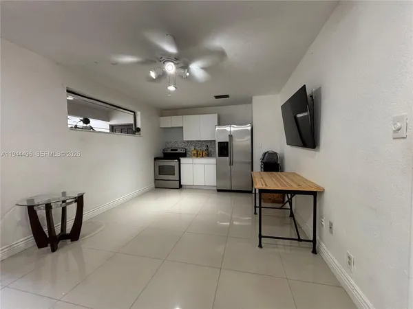 an empty room with windows and fireplace