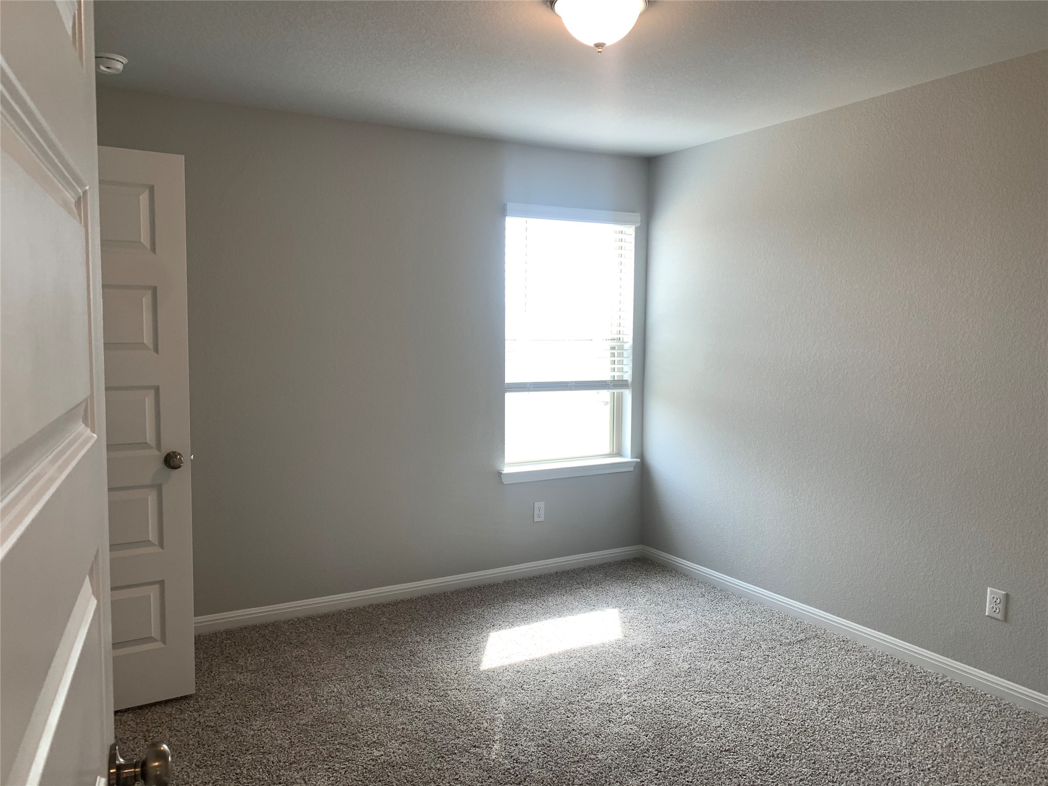 2948 Sage Ranch Drive Leander, TX 78641 - Photo 18 of 28 A well-lit bedroom features plush carpeting and a clear window, offering a comfortable personal retreat.