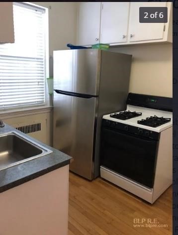 1490 Beacon Street, Unit 2 Brookline, MA 02446 - Photo 3 of 6 a kitchen with granite countertop a sink and a stove