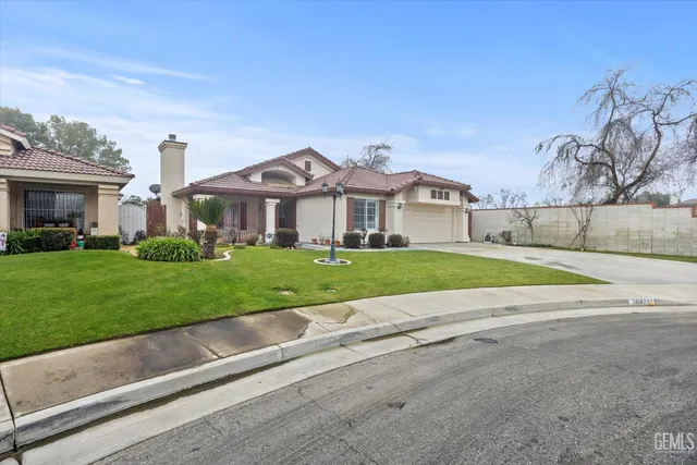 a view of house with a big yard and potted plants